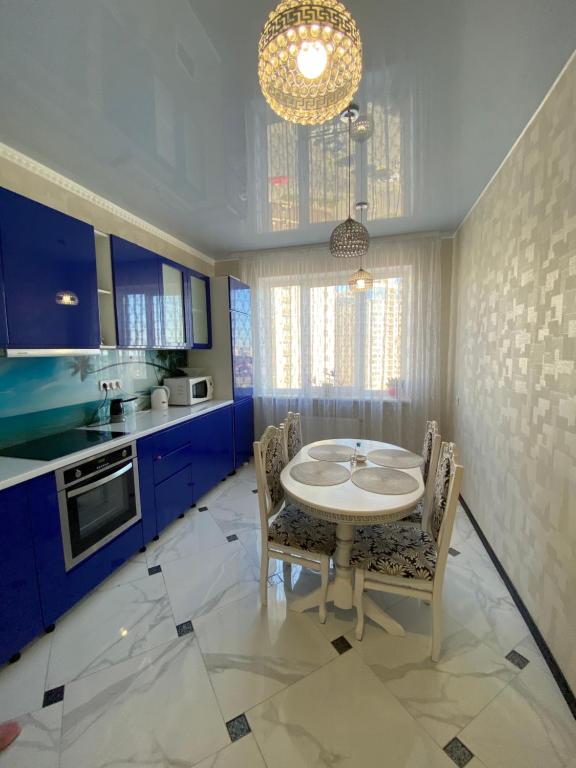 Odessa的住宿－Odessa Pearl Apartment，厨房配有蓝色橱柜和桌椅