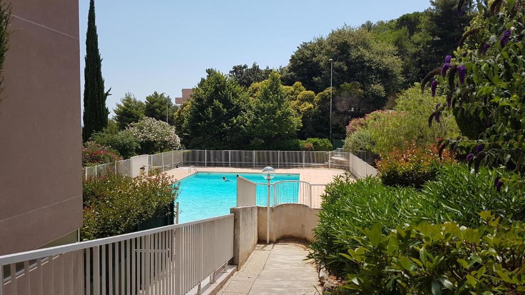 une piscine dans un jardin avec une clôture dans l'établissement Park Fabron 2 Pieces Terrasse Piscine Parking, à Nice
