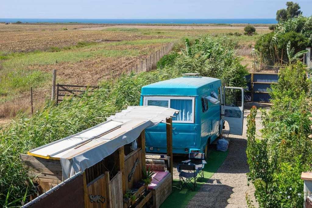 Un camión azul está estacionado en un campo en JABUTI Autocaravana con porche y aparcamiento en Cádiz