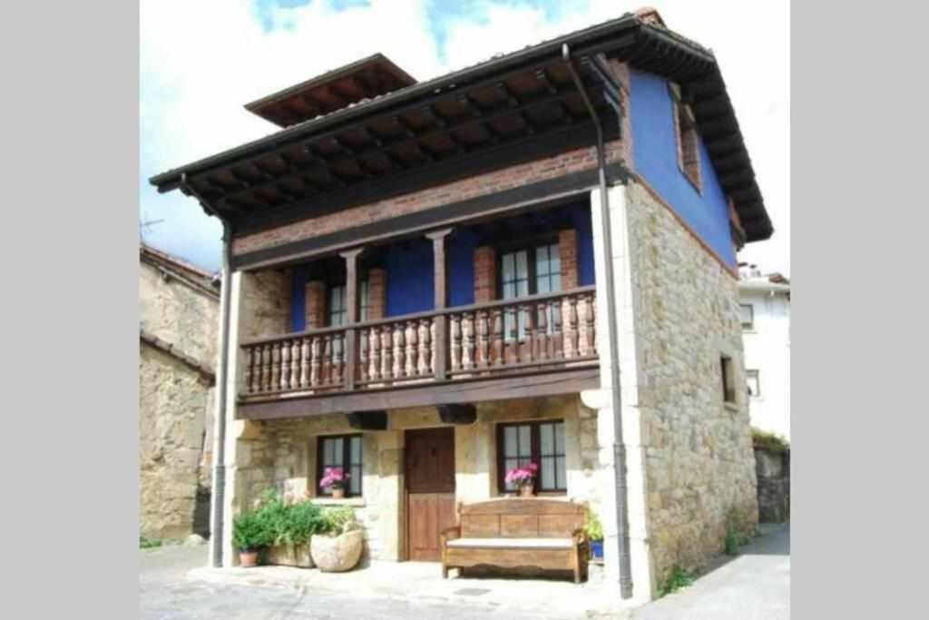 una casa con balcón en la parte superior en La Regenta Picos de Europa, en Poo de Cabrales