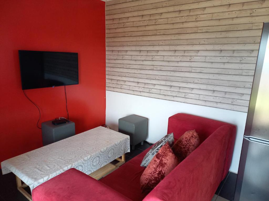 a red living room with a couch and a tv at 2 Bedroom Residential Home, along the coast. in Durban
