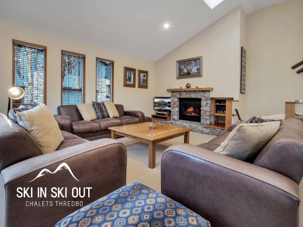 a living room with couches and a fireplace at On The Snow 1 in Thredbo
