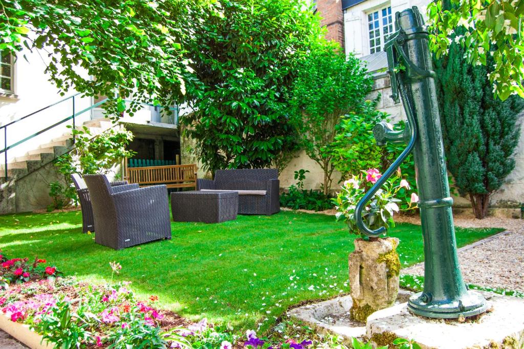 um jardim com cadeiras e um poste de luz em Les Chambres Panda em Saint-Aignan