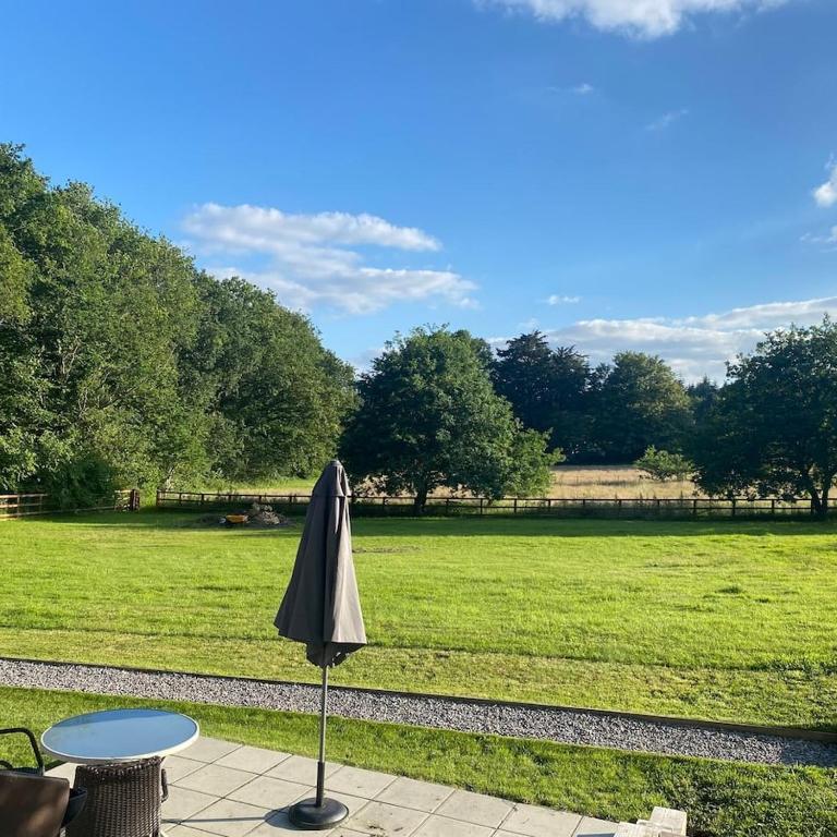 an umbrella sitting next to a table in a field at Haven Oaks - Self contained rural lodge 2 in Shedfield