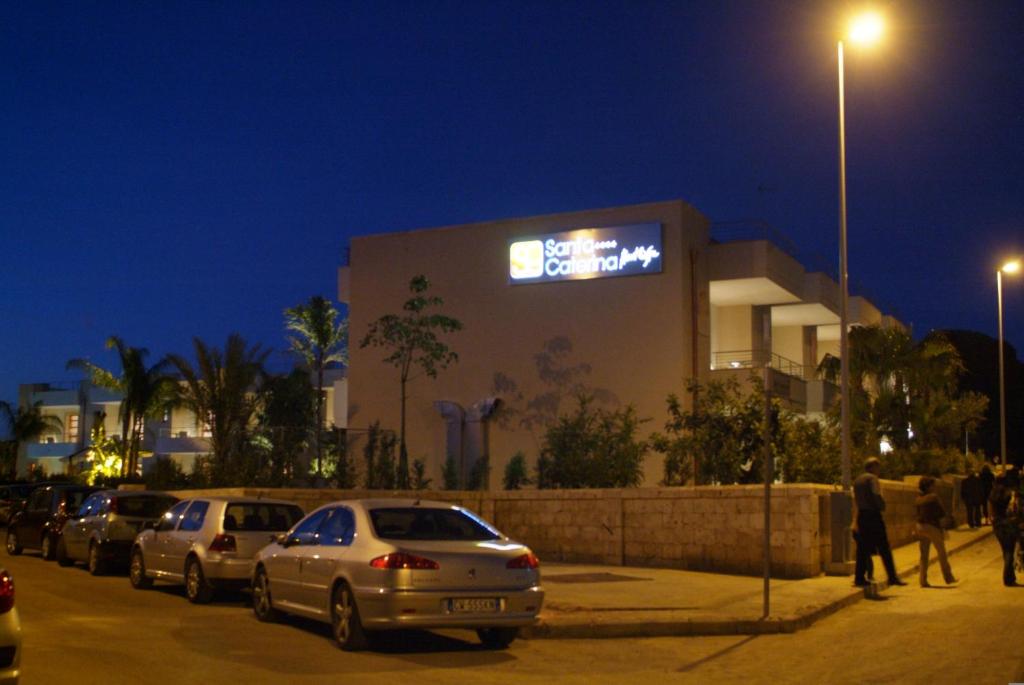 a building with cars parked in a parking lot at night at Santa Caterina Resort in Santa Caterina di Nardò