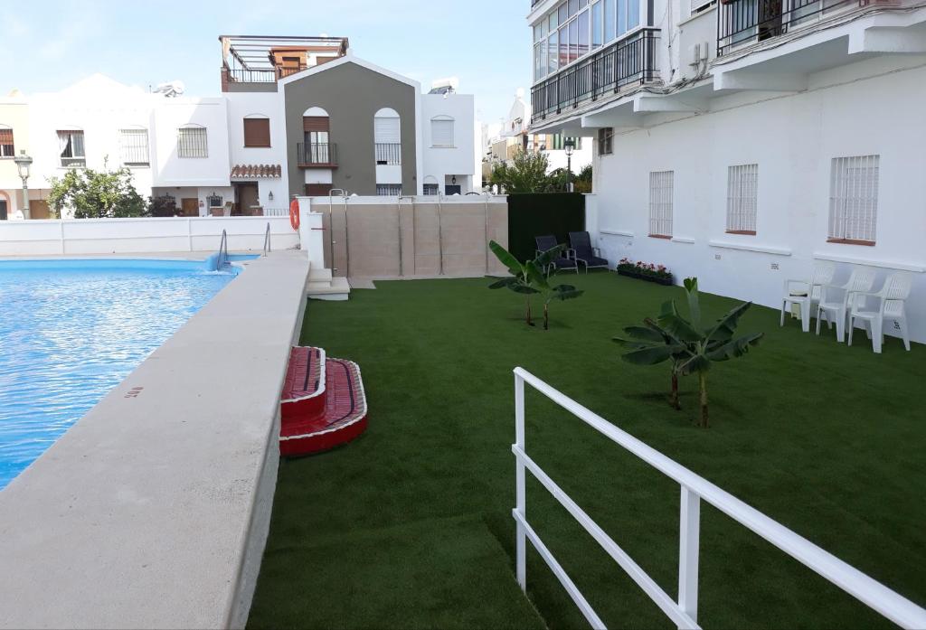 vistas a un patio con piscina y césped en Apartamentos Tursol, en Nerja