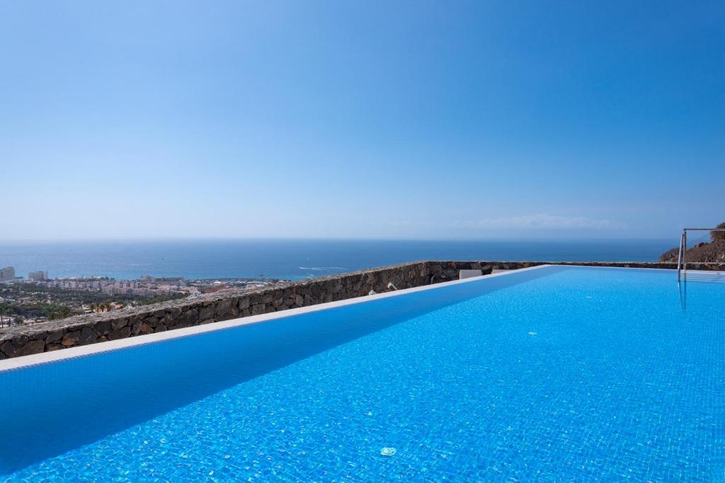 a infinity pool with the ocean in the background at Luxury Villa Maria private heated pool Free Car except Christmas in Adeje