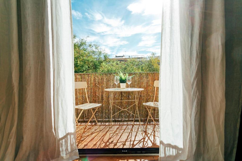 una finestra con vista da un patio con tavolo e sedie di Minty Stay 3BD Apartment - Triana a Siviglia