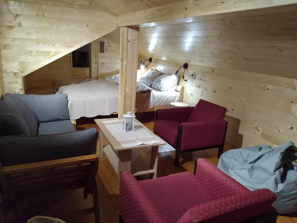 a room with a bed and a couch and chairs at Woodpeckers house in Zlatibor