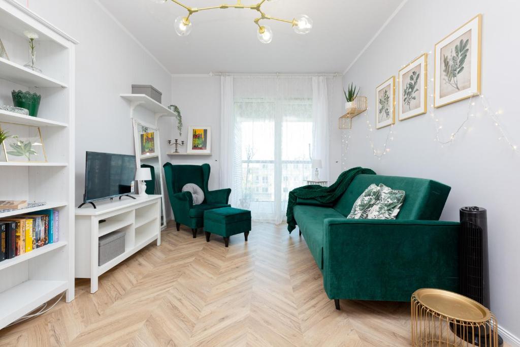 a living room with a green couch and two chairs at Amsterdam Estate Apartments Rembrandta in Warsaw