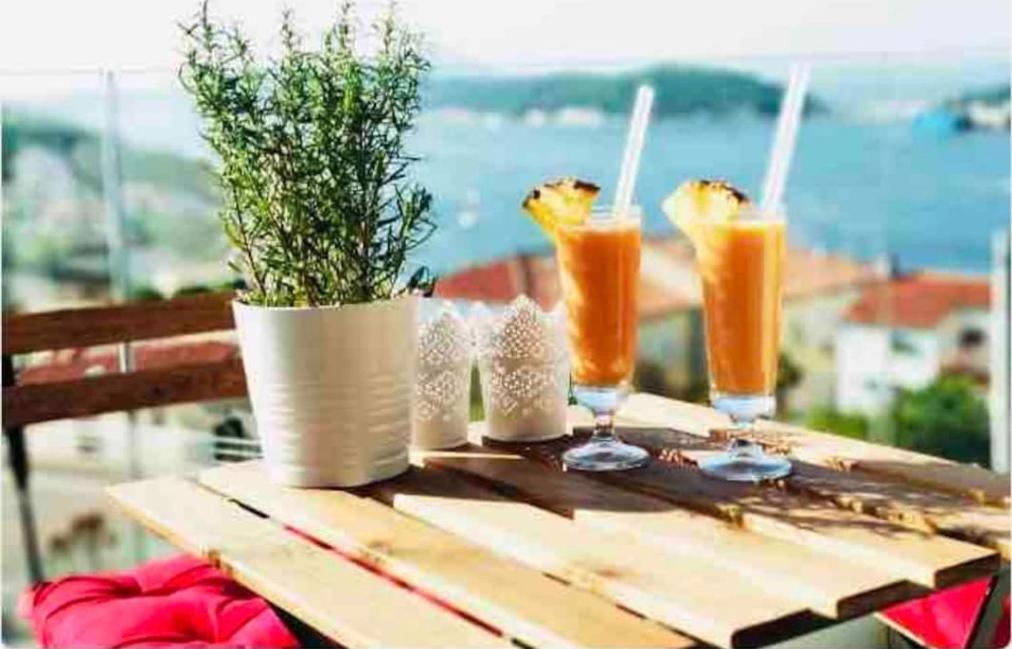 a wooden table with drinks and potted plants on it at Beautiful view apartment with garage space in Mali Lošinj