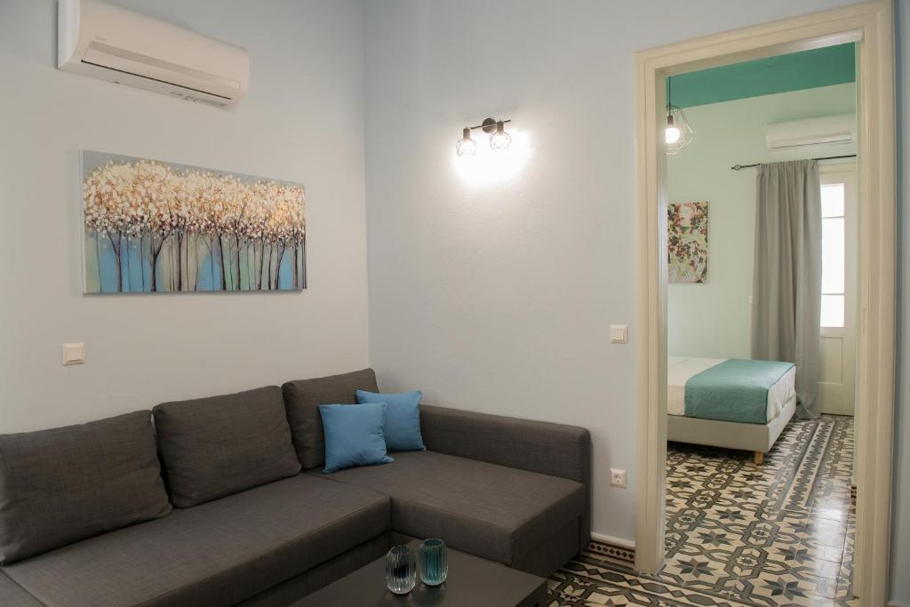 a living room with a couch and a bed at The Blue apartment in the heart of Heraklion in Heraklio