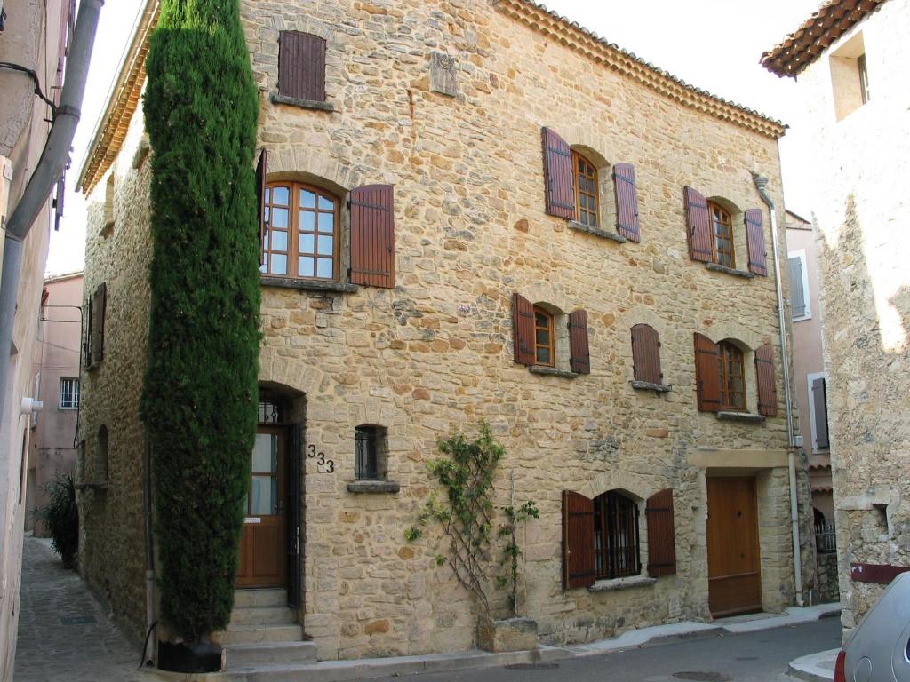 - un vieux bâtiment en pierre avec des portes et des fenêtres marron dans l'établissement Au 333, à Bédoin