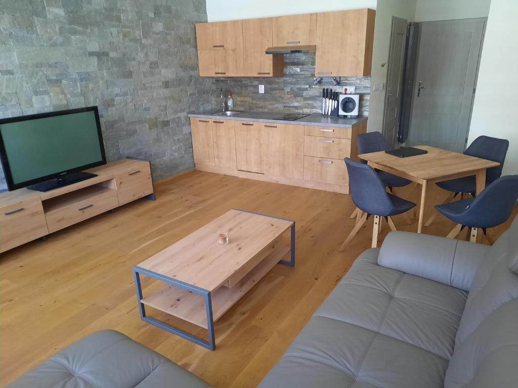 een woonkamer met een bank, een tv en een tafel bij Mýto apartments in Mýto pod Dumbierom