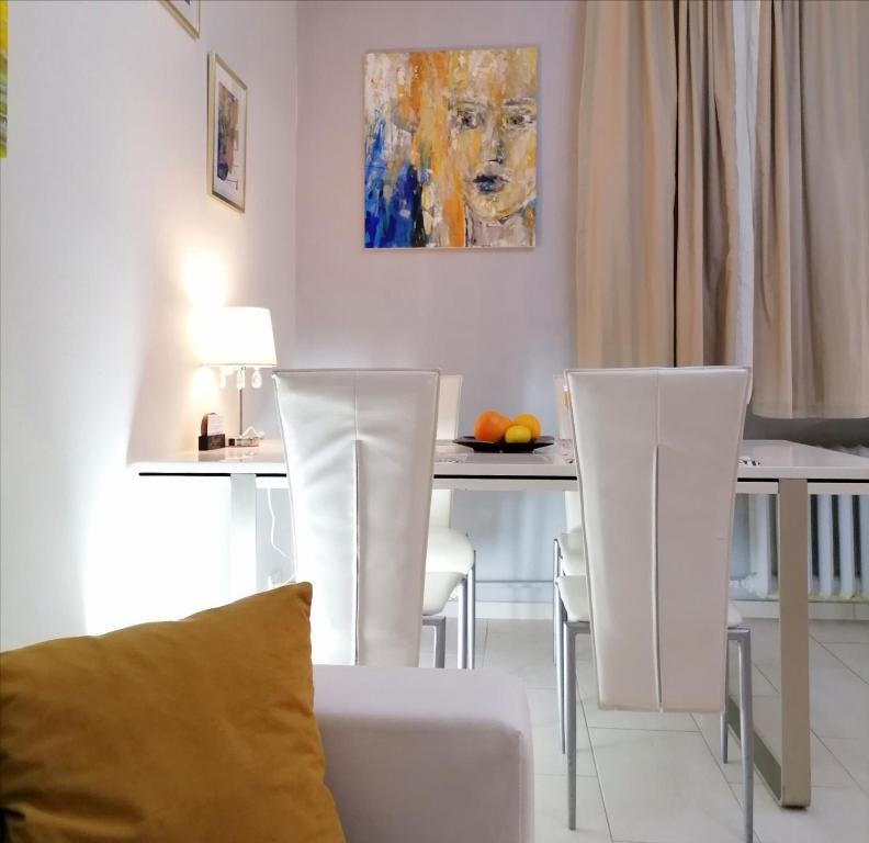 een woonkamer met een tafel met stoelen en een schilderij bij Metro Wilson Apartment in Warschau