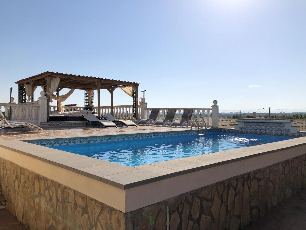 a swimming pool with a gazebo on a patio at 4 bedrooms villa with private pool enclosed garden and wifi at Olocau in Olocau