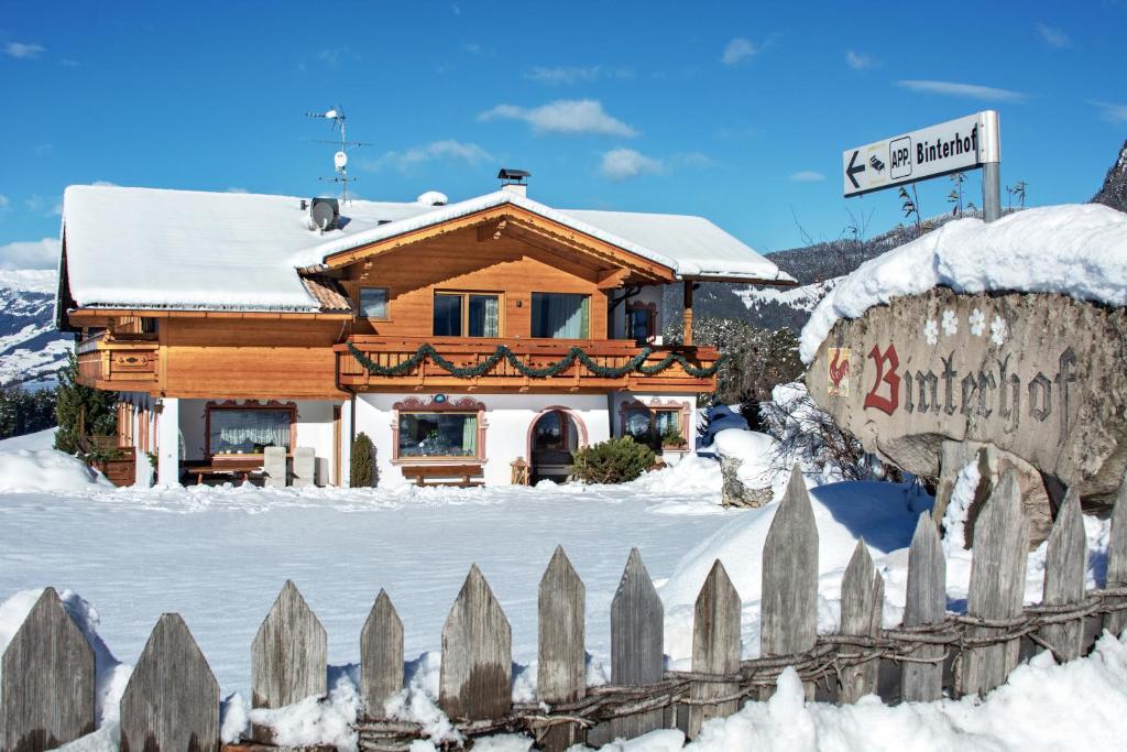 a wooden house in the snow with a fence at Binterhof in Castelrotto