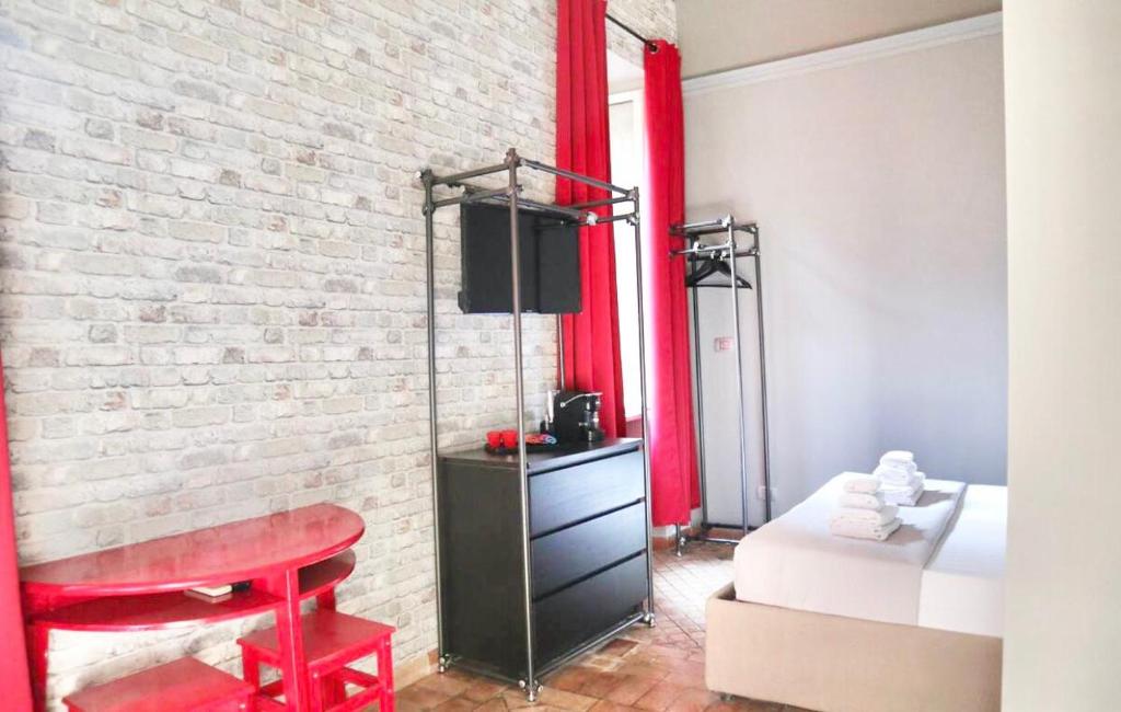 una camera da letto con un tavolo rosso e un muro di mattoni di Pantheon Palazzo Lanzi a Roma