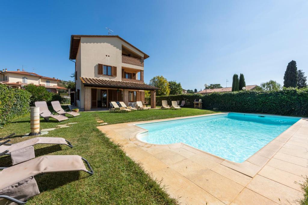 Villa con piscina frente a una casa en Villa Clemente, en Lucignano