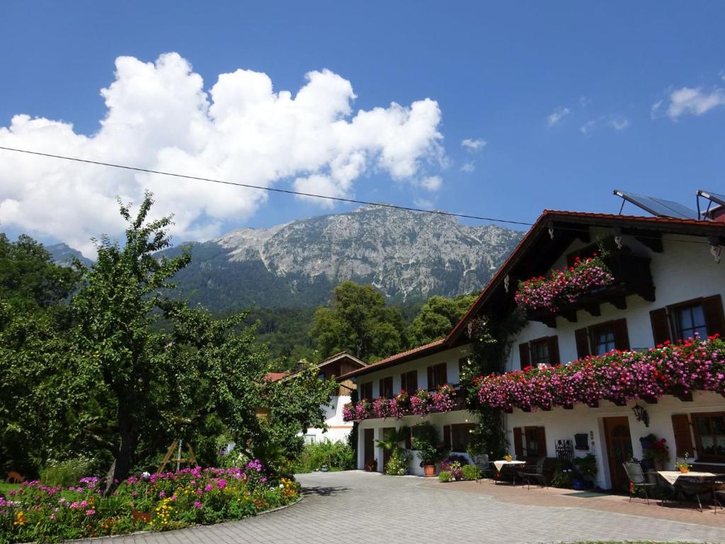 a building with flowers in front of a mountain at Ferienwohnungen Auhaus in Bad Reichenhall