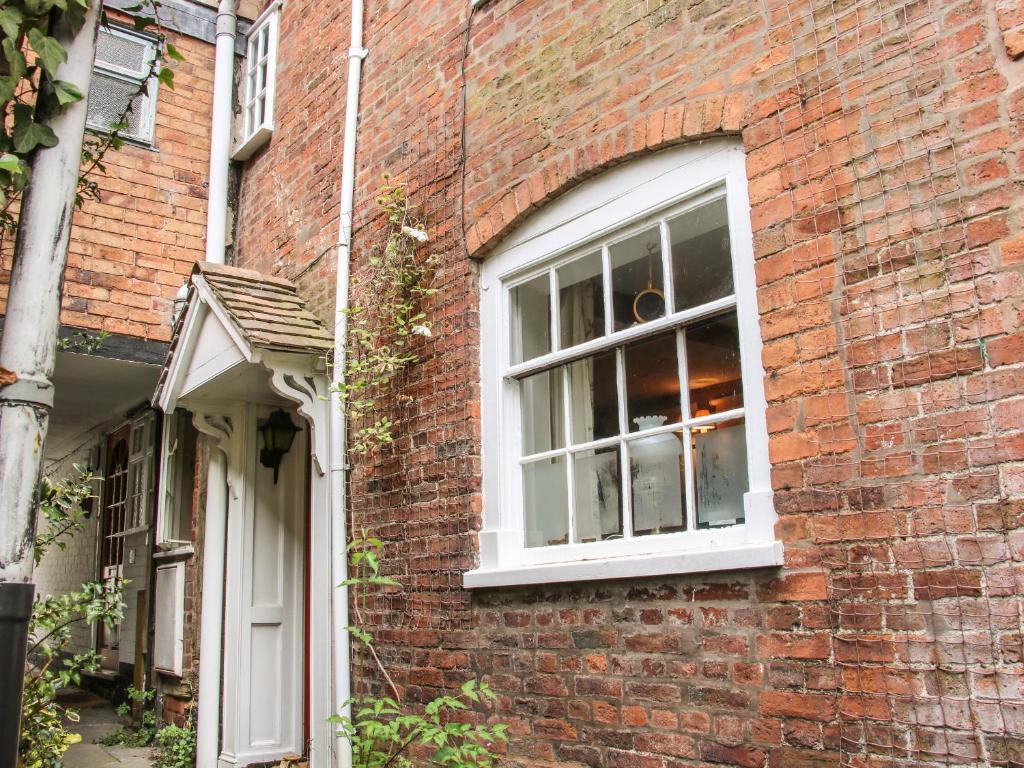 a brick building with a window and a door at 55 Corve Street in Ludlow