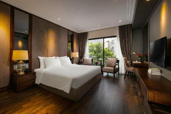 sypialnia z dużym białym łóżkiem i telewizorem w obiekcie PING DIAMOND HOTEL w mieście Hanoi