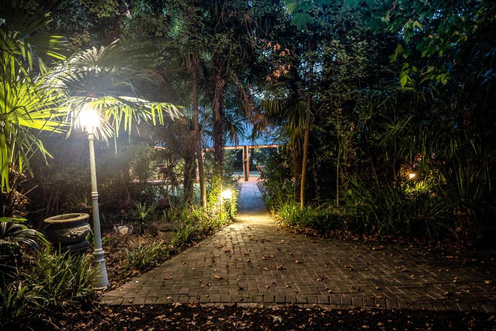 a walkway in a park at night with a street light at Winterton Country Lodge @ Rose Cottage in Winterton