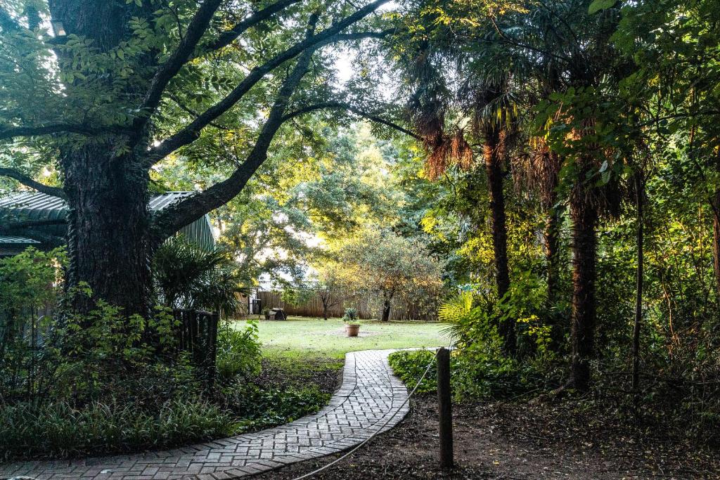 a stone path in a park with a tree at Winterton Country Lodge @ Rose Cottage in Winterton
