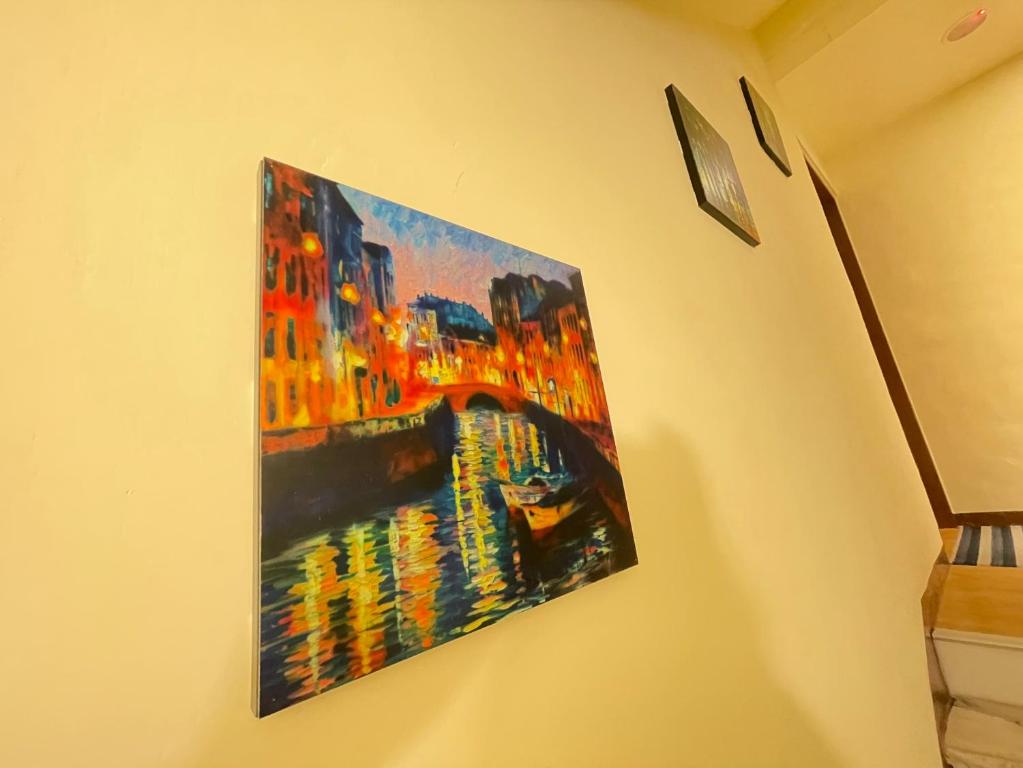 a painting hanging on a wall on a wall at 墾丁聚點旅棧 2Ps Hotel in Kenting