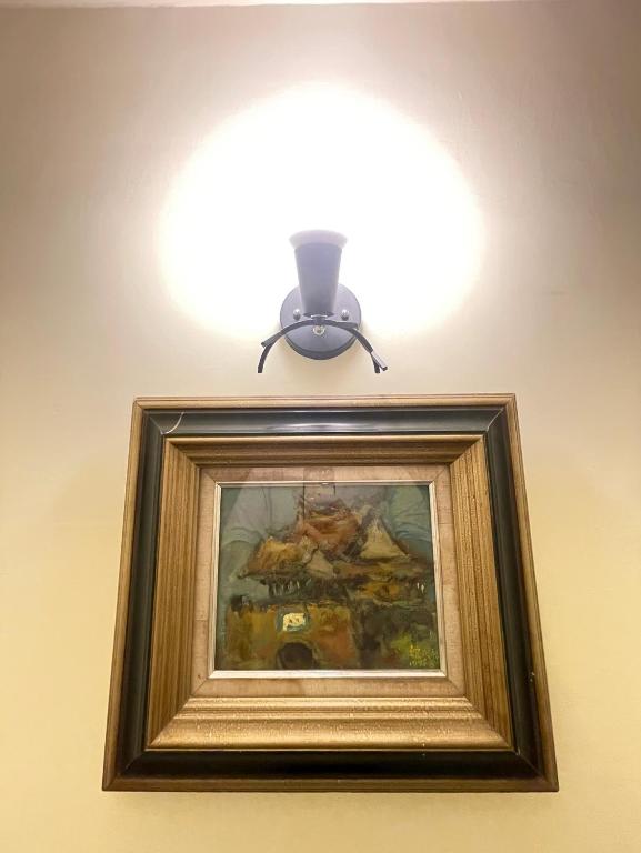 a light on top of a painting on a wall at 墾丁聚點旅棧 2Ps Hotel in Kenting