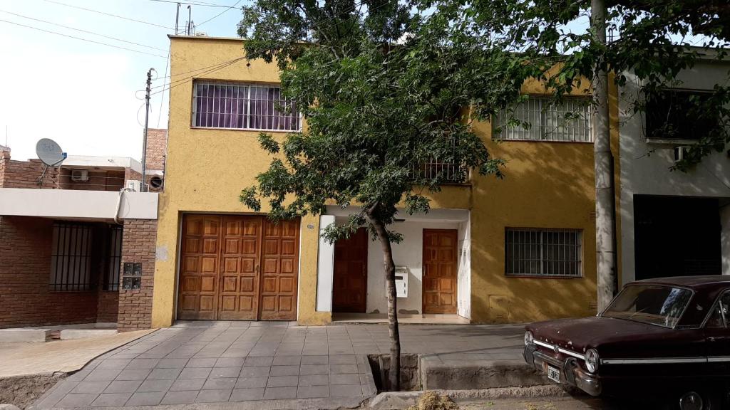 an old car parked in front of a yellow building at Suipacha in Mendoza