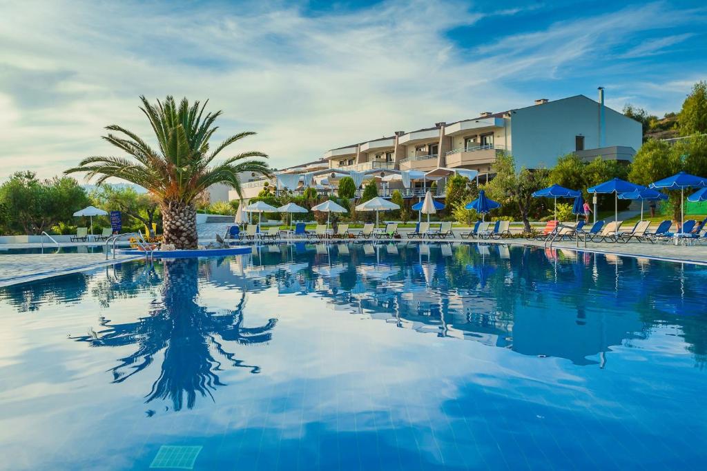 a large swimming pool with chairs and umbrellas at Xenios Anastasia Resort & Spa in Nea Skioni