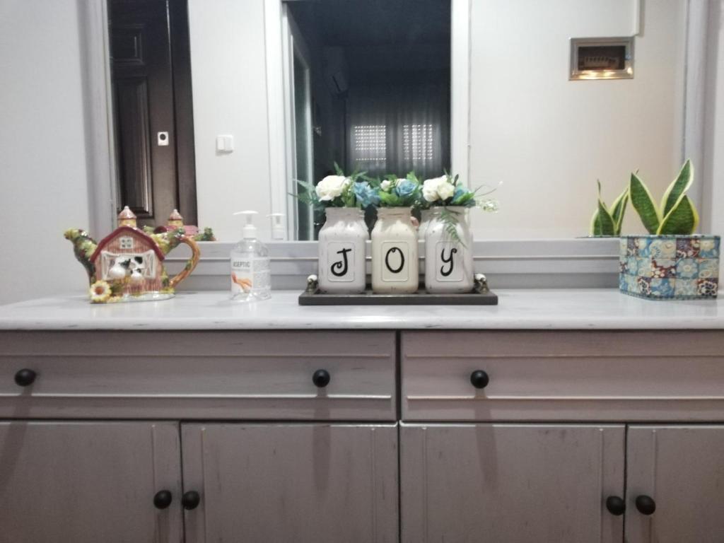 a dresser with a mirror and flowers on it at Pepper House Edessa in Edessa