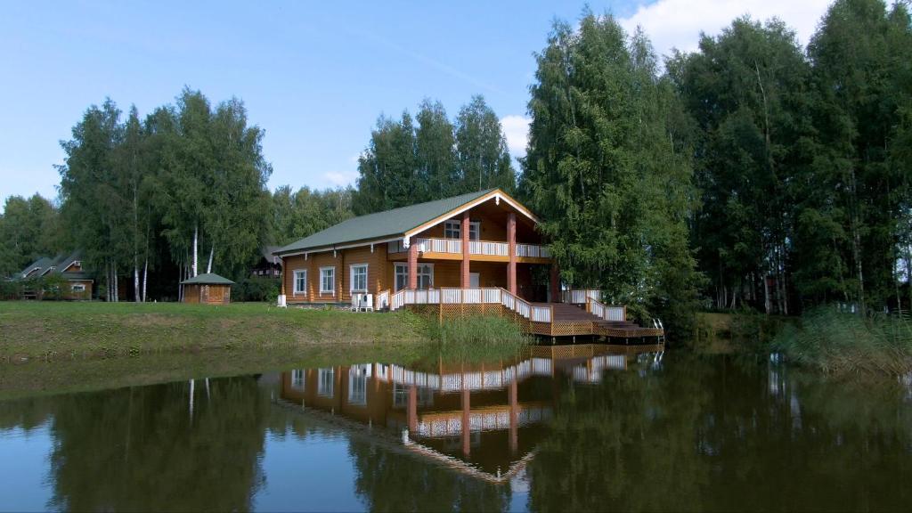 una casa sentada al lado de un cuerpo de agua en Парк-Отель Басовское en Selishche