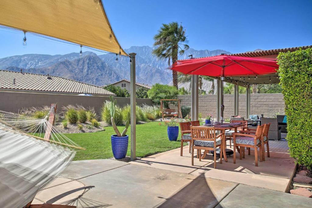 un patio con una mesa y una sombrilla roja en Palm Springs Home Mountain Views, Near Downtown!, en Palm Springs