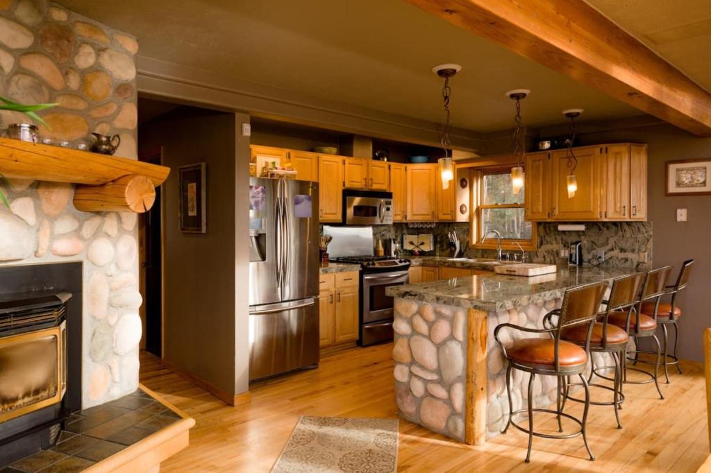 eine Küche mit einer Bar und einem Steinkamin in der Unterkunft Spectacular Mountain Top Property in Morrison