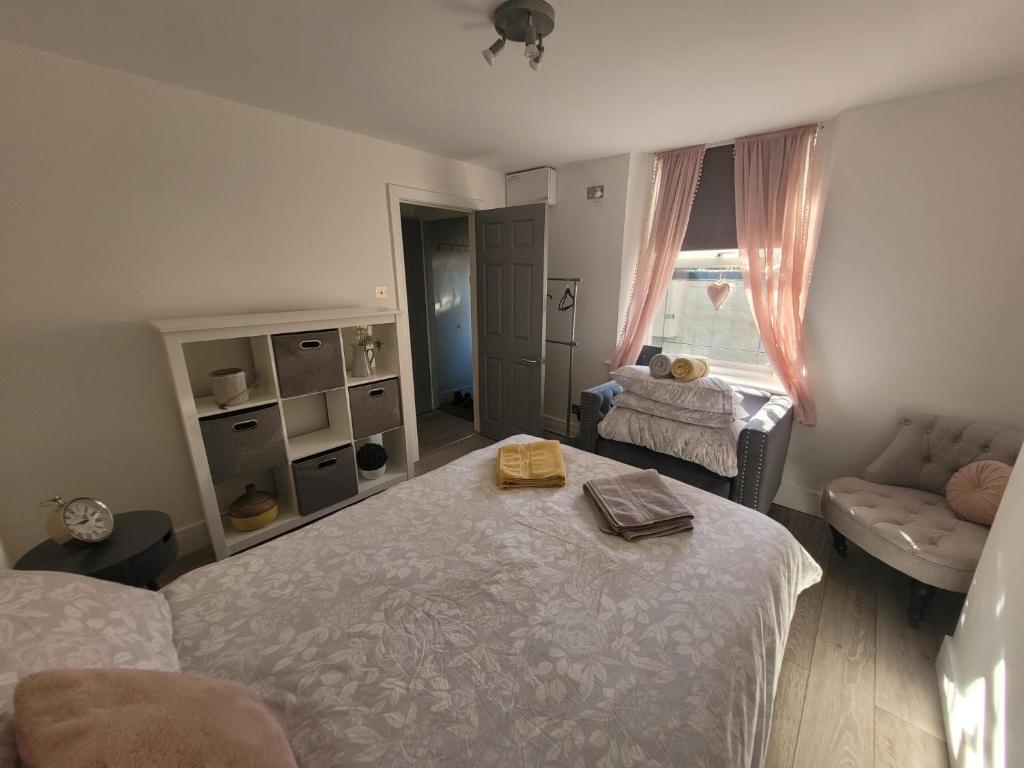 a bedroom with a large bed and a couch at Entire apartment with sun filled private garden in Margate