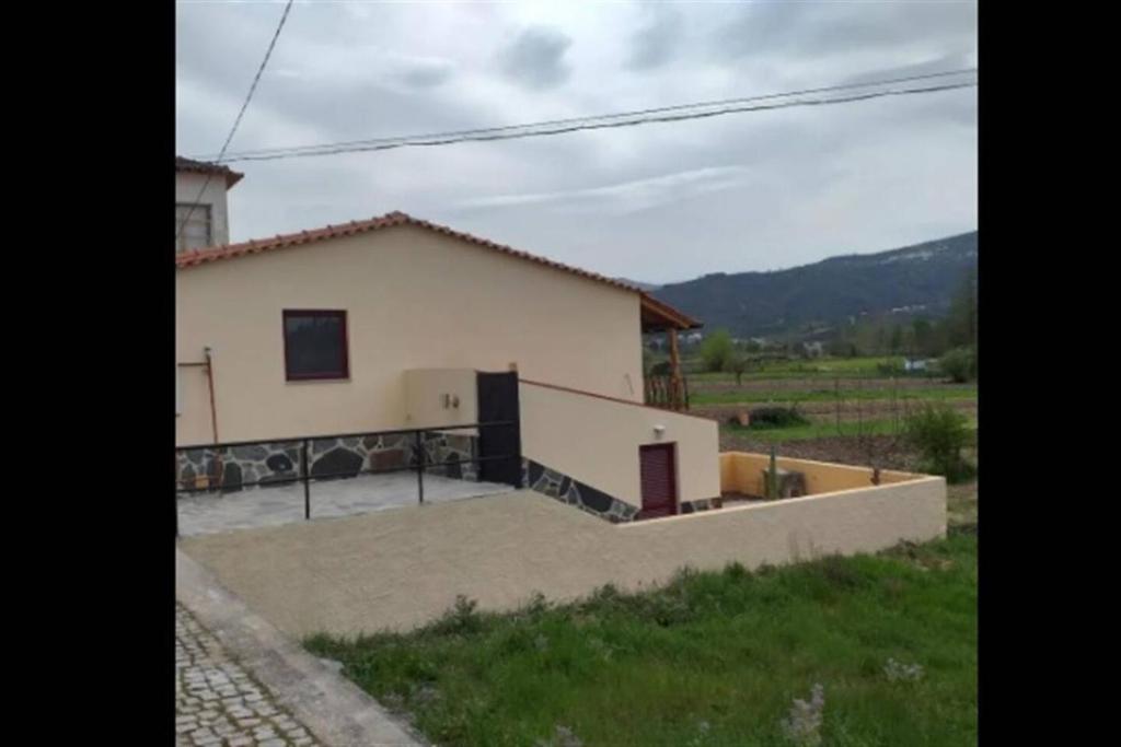 a house with a large patio in front of it at a pequena Casa coja central portugal mountains in Coja