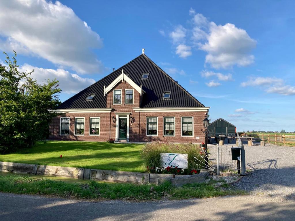 une grande maison en briques avec un toit noir dans l'établissement B&B Zunderdorp, à Amsterdam