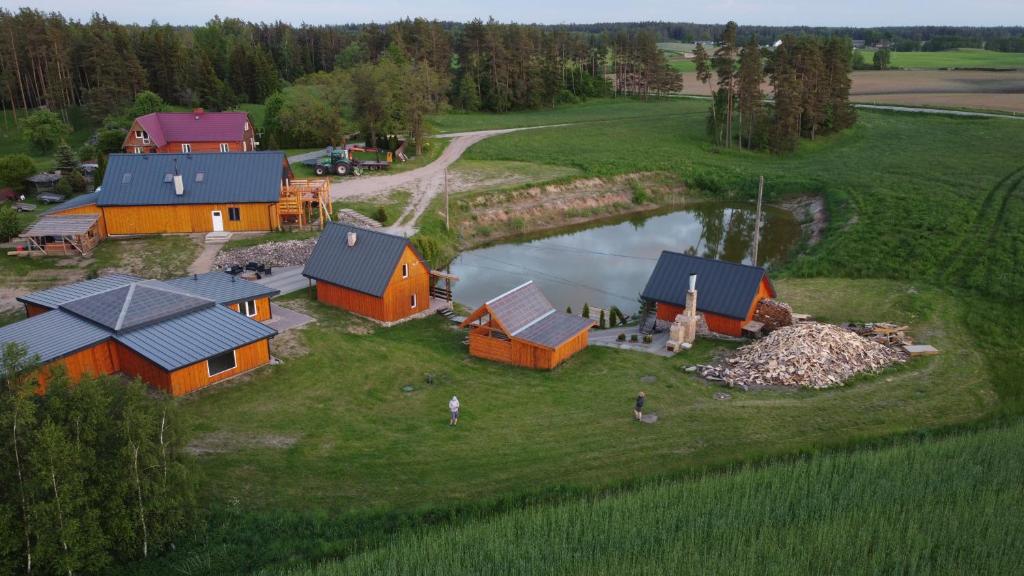 an aerial view of a farm with buildings and a pond at Domek Pod Akacjami in Szypliszki