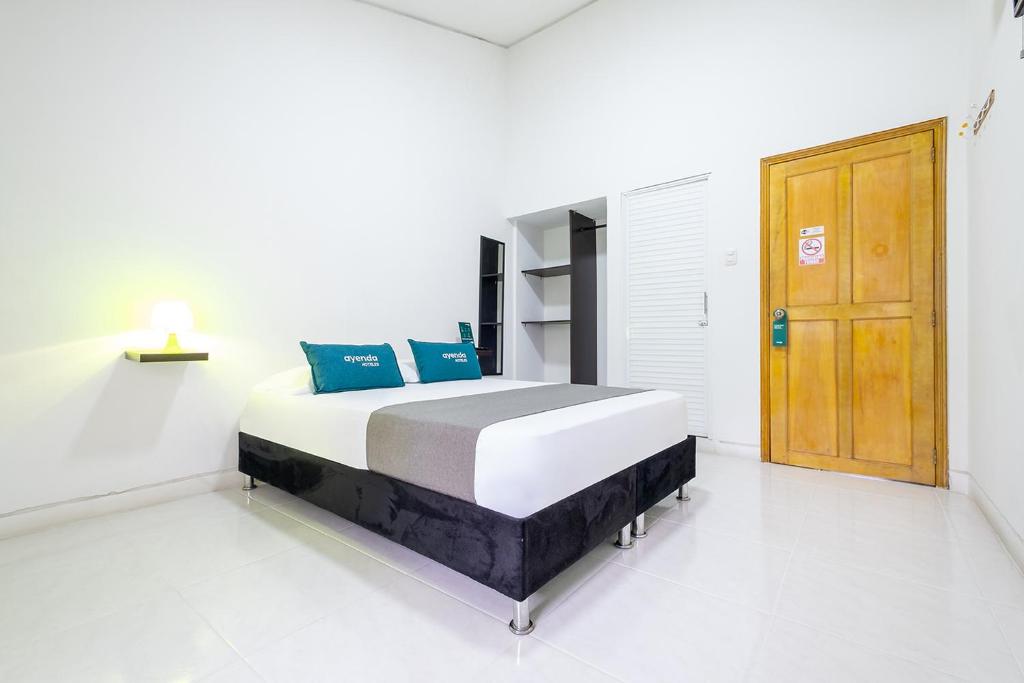 布卡拉曼加的住宿－Ayenda Antiguo Campestre，一间卧室配有一张带蓝色枕头的床。