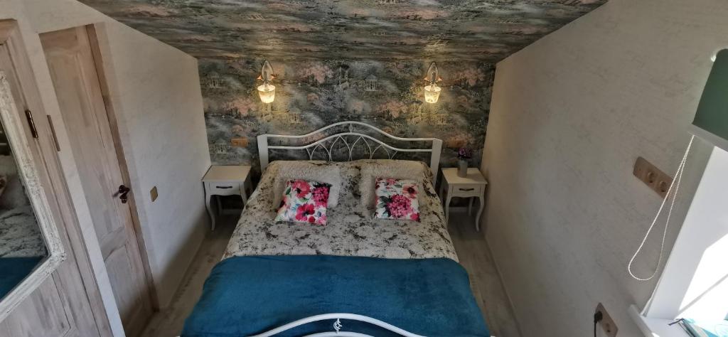 een kleine slaapkamer met een bed met 2 kussens bij Old Town Apartments in Jēkabpils