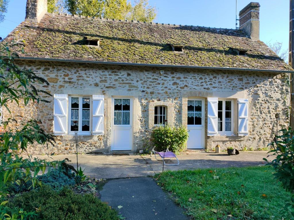 Casa de piedra antigua con puertas y ventanas blancas en "Rêves de Gamins" Chambre de gauche, 4 couchages dans gîte de campagne "La Camusière", proche du Pôle Européen et du circuit des 24h, en Champagné