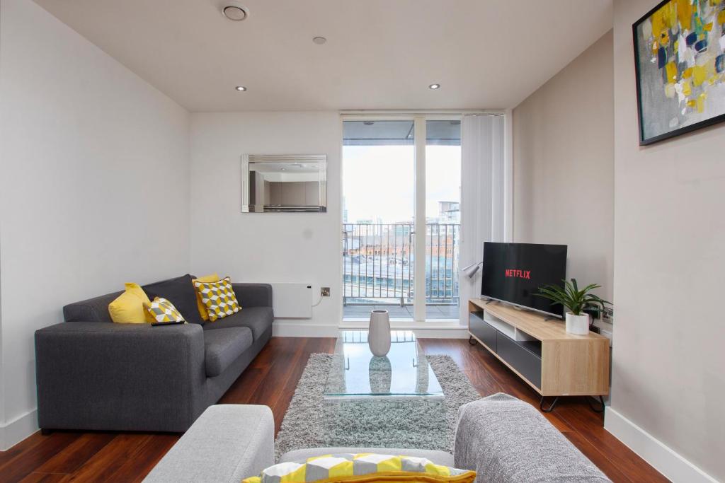 a living room with a couch and a tv at Central Manchester 2 Bed - Parking - Sleeps 4 in Manchester