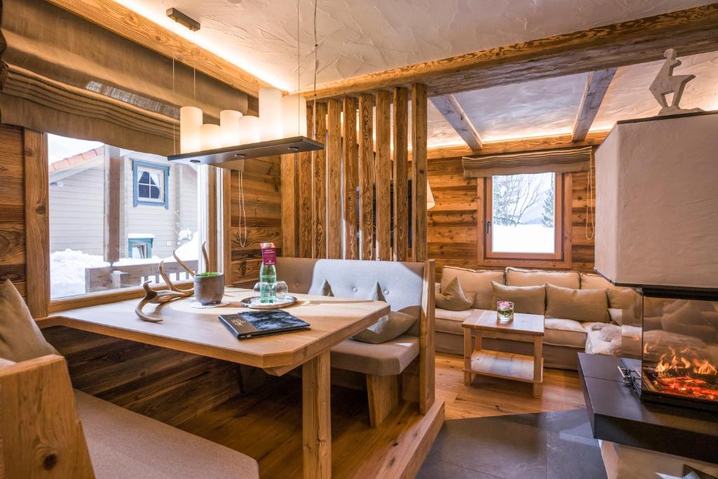 un soggiorno con un tavolo e un divano di Hotel Leitenhof 4 Sterne Superior a Scheffau am Wilden Kaiser