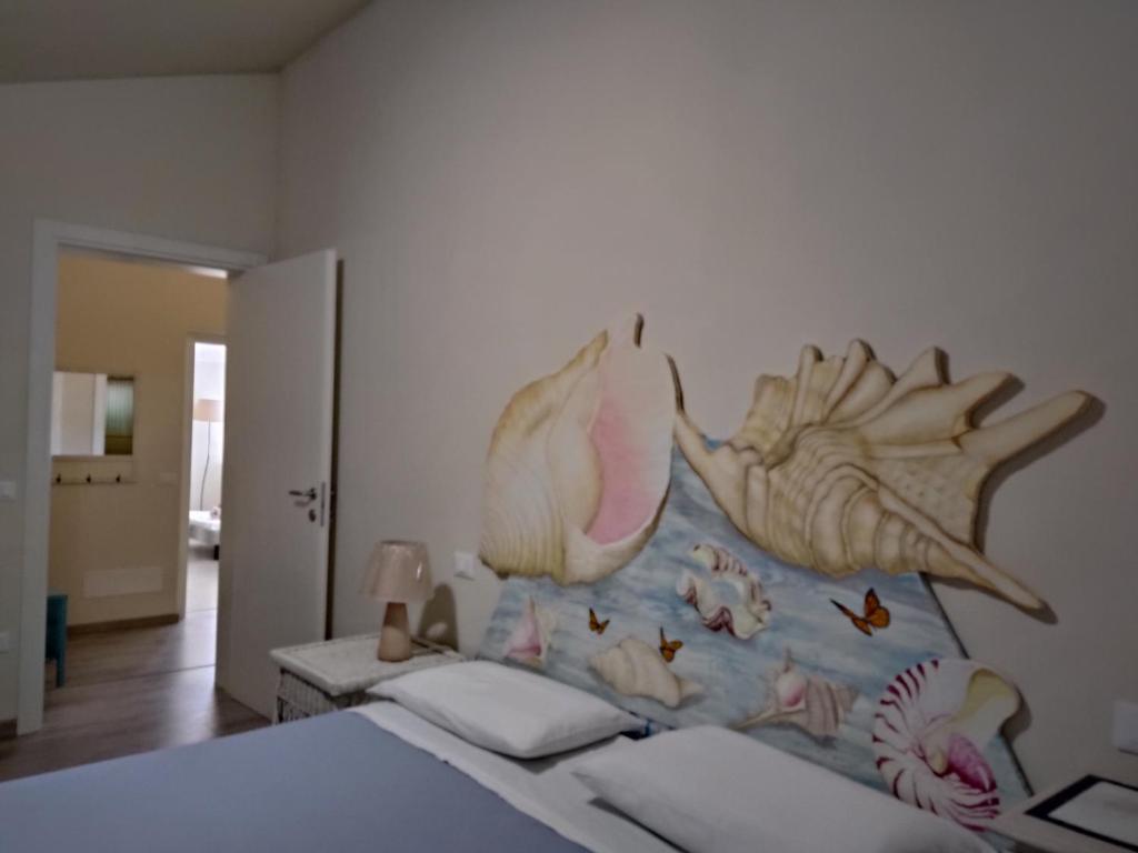 um quarto com uma cama com um mural de peixe na parede em Villa Carol "Ortensia1" "Ortensia 2" em Tollo