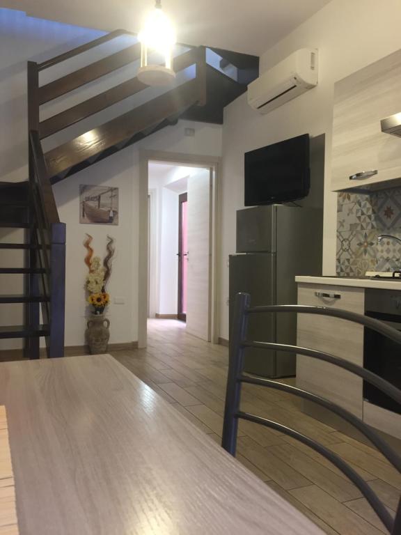 uma sala de estar com uma escada e uma cozinha em Domus Anna em Selargius