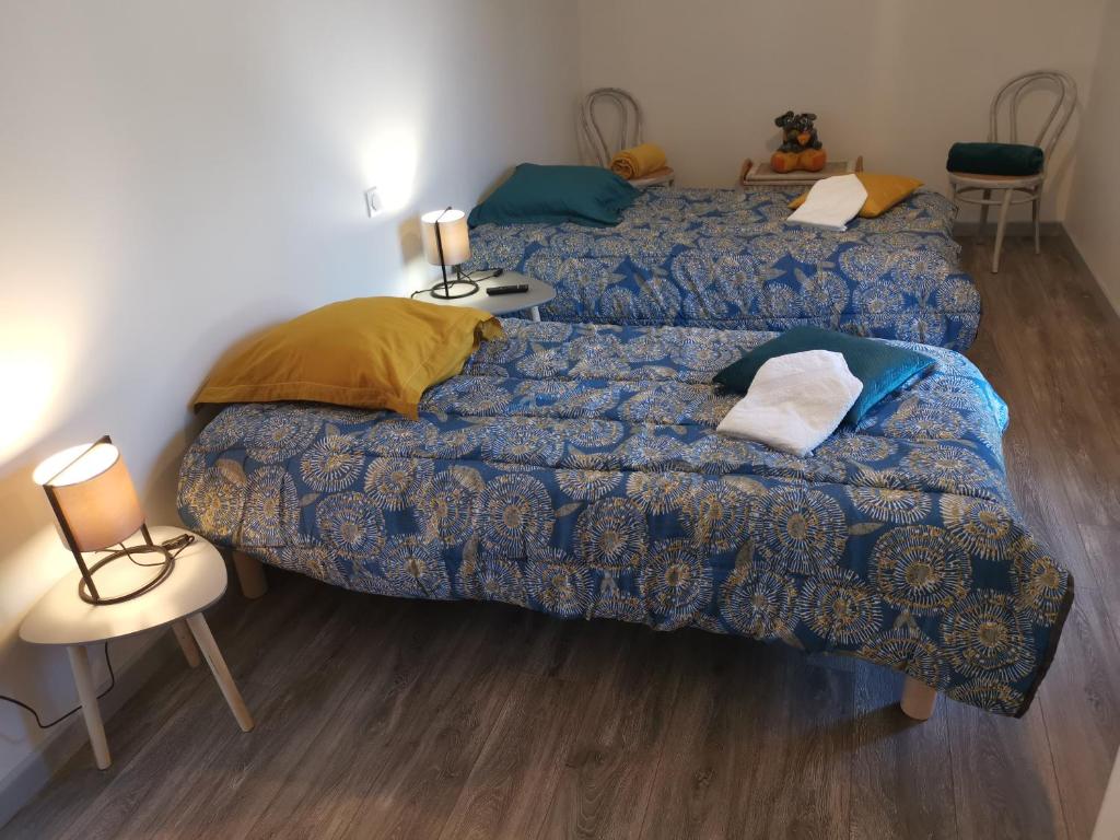 a bedroom with two beds and two tables and chairs at Les Hortensias in Lassay