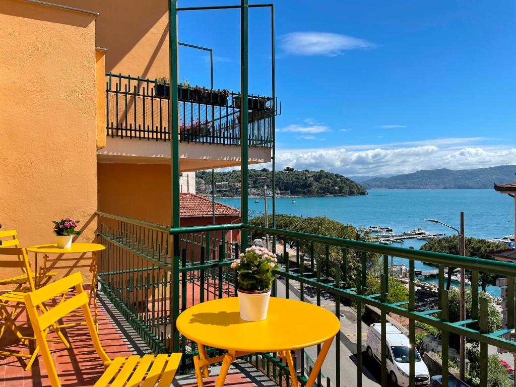 einen gelben Tisch und Stühle auf einem Balkon mit Blick auf das Wasser in der Unterkunft Casa Irene terrazza vista mare e garage in Porto Venere