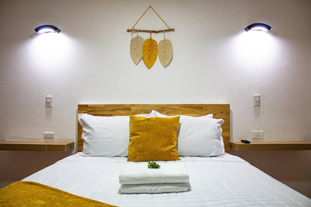 a bedroom with a bed with two lights on the wall at Very Special Place Apto in Guatemala